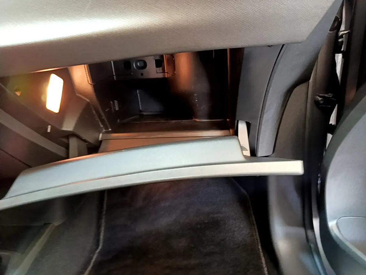 Ouverture du rangement réfrigéré gris clair côté passager dans l'habitacle du Citroën Grand C4 SpaceTourer gris foncé.