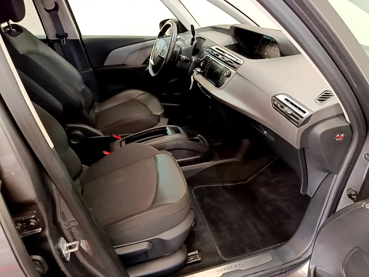 Vue intérieure côté conducteur du Citroën Grand C4 Spacetourer gris foncé, avec tableau de bord et sièges noirs.