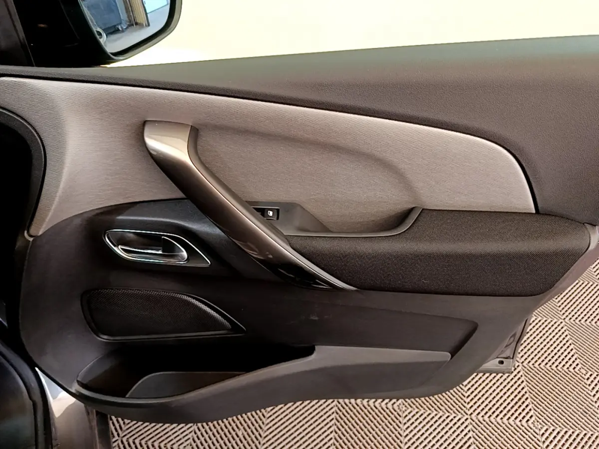Vue rapprochée de la porte côté gauche du Citroën Grand C4 SpaceTourer gris foncé, avec poignée argentée et garniture noire.