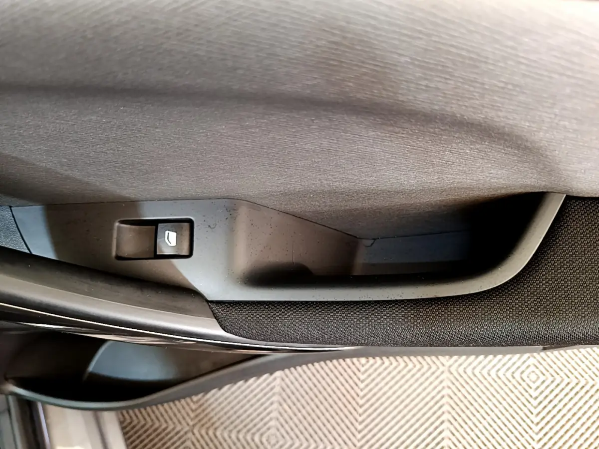 Bouton de déverrouillage porte arrière côté gauche du Citroën Grand C4 SpaceTourer gris foncé, vue rapprochée intérieure.
