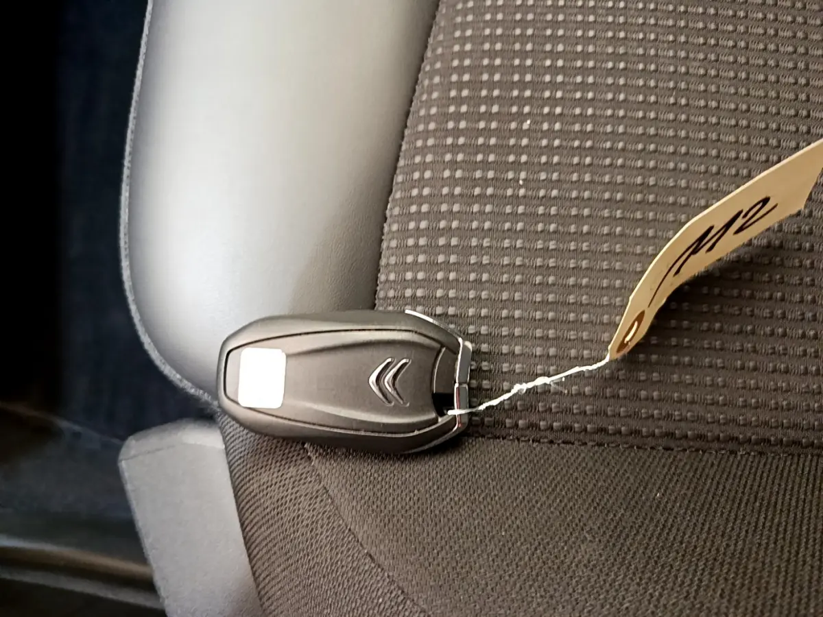 Clé de démarrage noire Citroën posée sur un siège tissu gris foncé à motifs carrés dans un Grand C4 Spacetourer 2022.