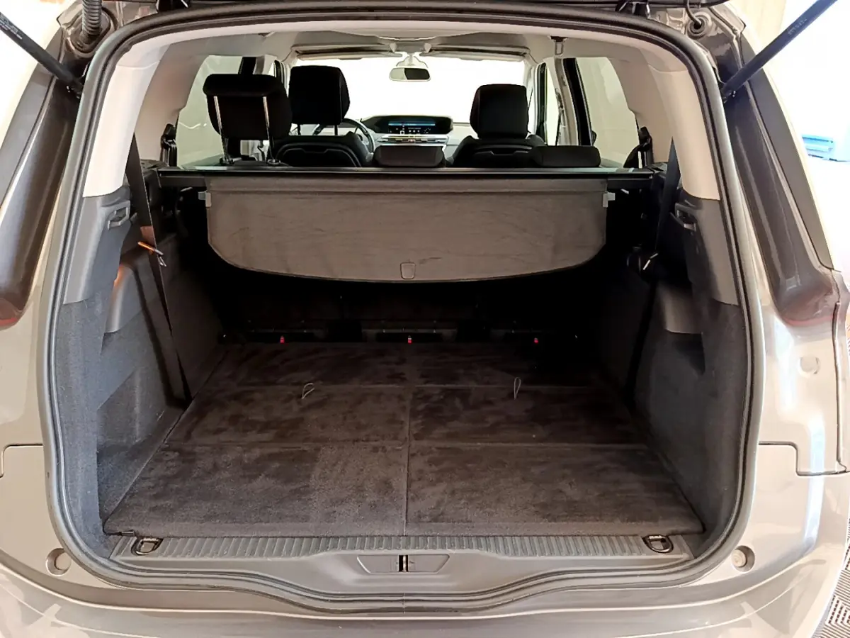 Coffre ouvert d'un Citroën Grand C4 Spacetourer gris foncé, vue arrière montrant le plancher plat et la tablette cache-bagages.