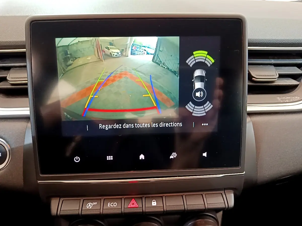 Écran tactile central du tableau de bord du Renault Captur noir, affichant la caméra de recul et capteurs de stationnement.