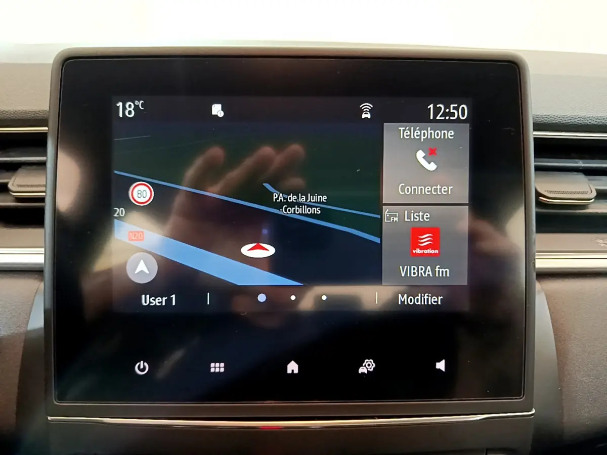 Écran tactile central du tableau de bord du Renault Captur Business noir, affichant navigation et options téléphone à 12h50.