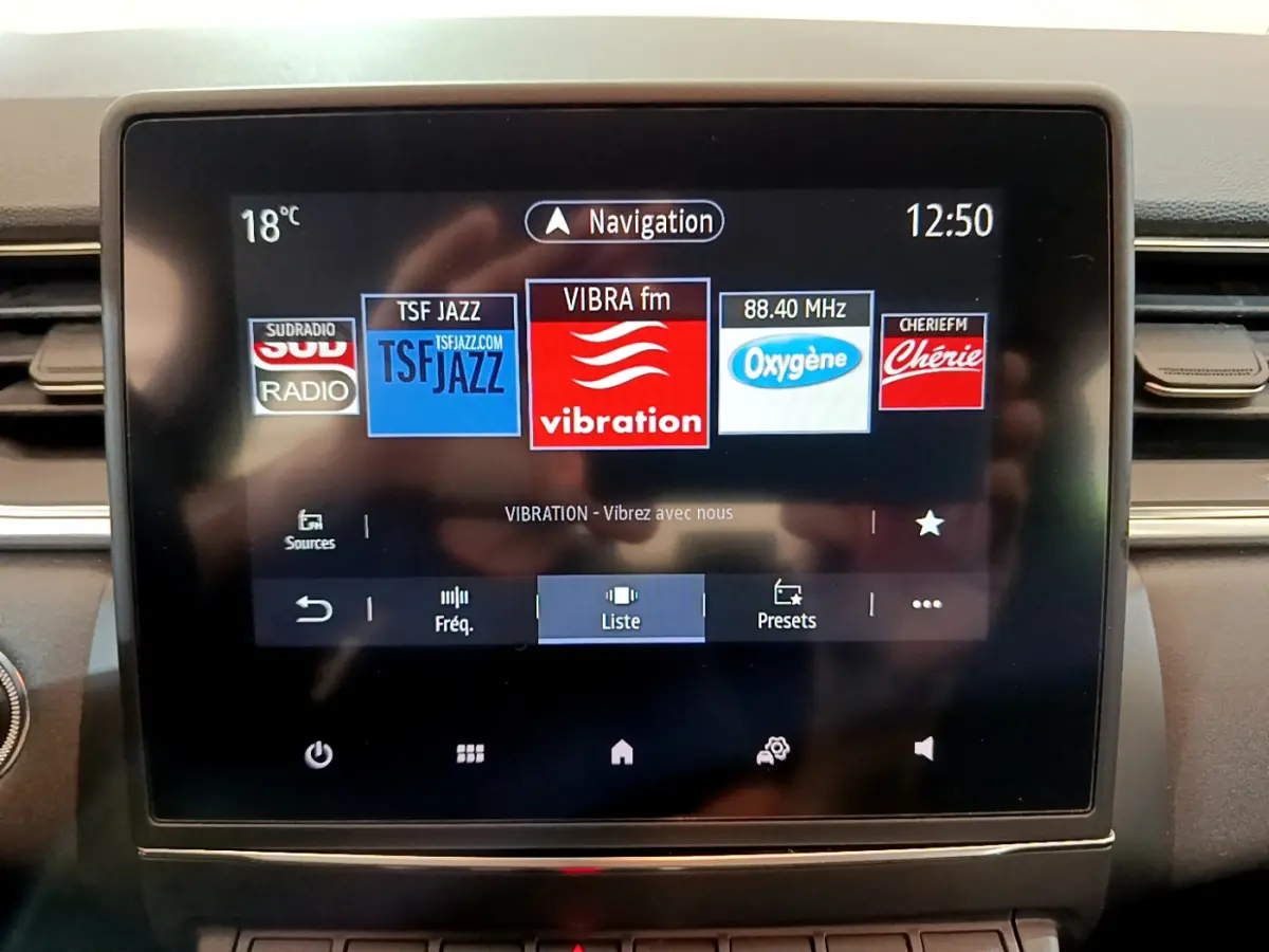 Écran tactile central du tableau de bord du Renault Captur Business noir, affichant les radios disponibles.
