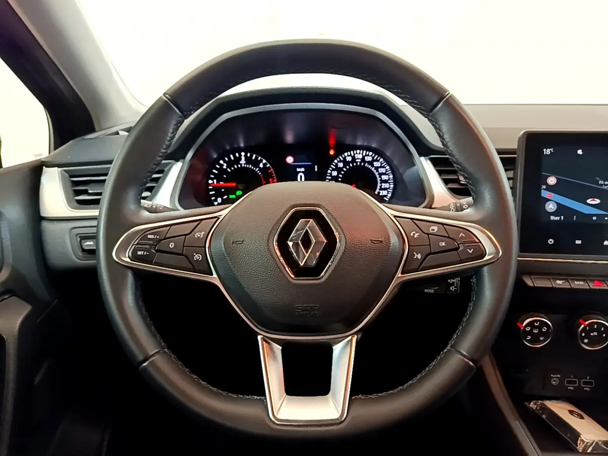 Vue rapprochée du volant noir de Renault Captur 2020 avec tableau de bord et écran tactile central visibles.