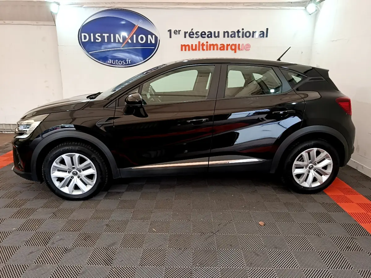 Profil côté gauche du Renault Captur Business Blue dCi 95 noir, vue intérieure d'un showroom avec logo Distinxion en arrière-plan.