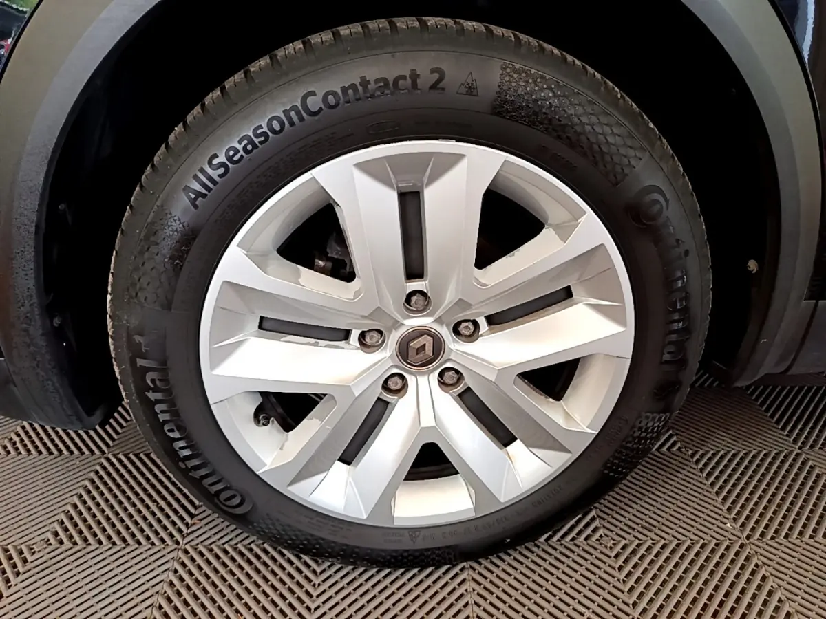 Gros plan sur la roue avant gauche du Renault Captur noir, mettant en valeur la jante alliage et le pneu Continental AllSeasonContact 2.