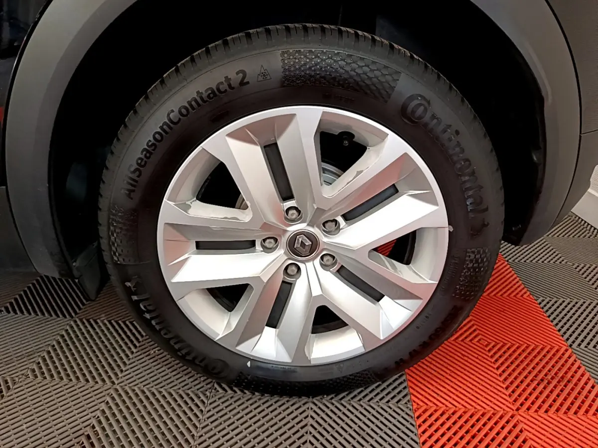 Gros plan sur la roue avant droite du Renault Captur noir, mettant en valeur la jante argentée et le pneu Continental.