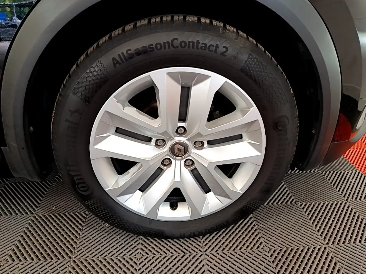 Gros plan sur la roue avant droite avec jante argentée et pneu Continental AllSeasonContact 2 du Renault Captur noir 2020.