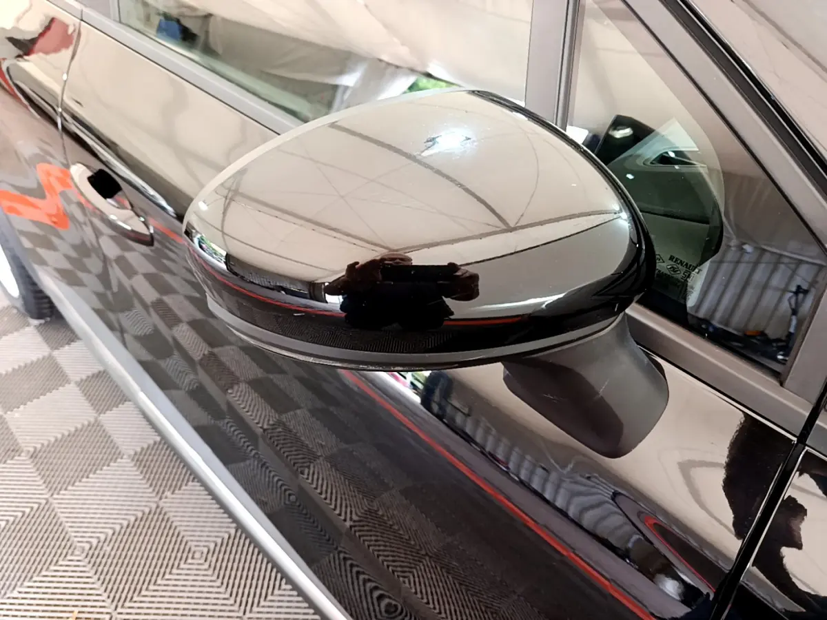 Rétroviseur côté gauche noir brillant d’un Renault Captur Business 2020, vue rapprochée sur la portière et la vitre.