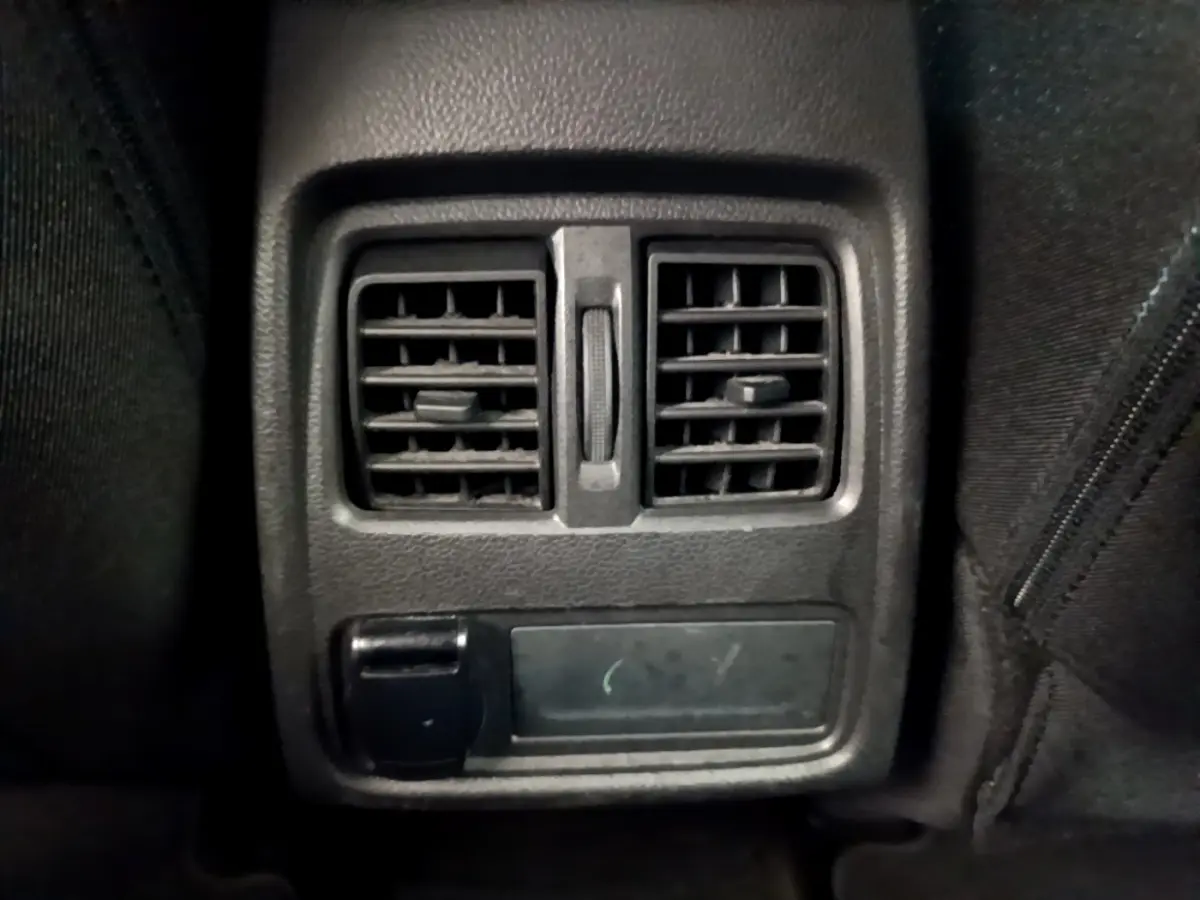 Gros plan sur la sortie d'air arrière noire du Renault Captur Business Blue dCi 95, intérieur sombre.