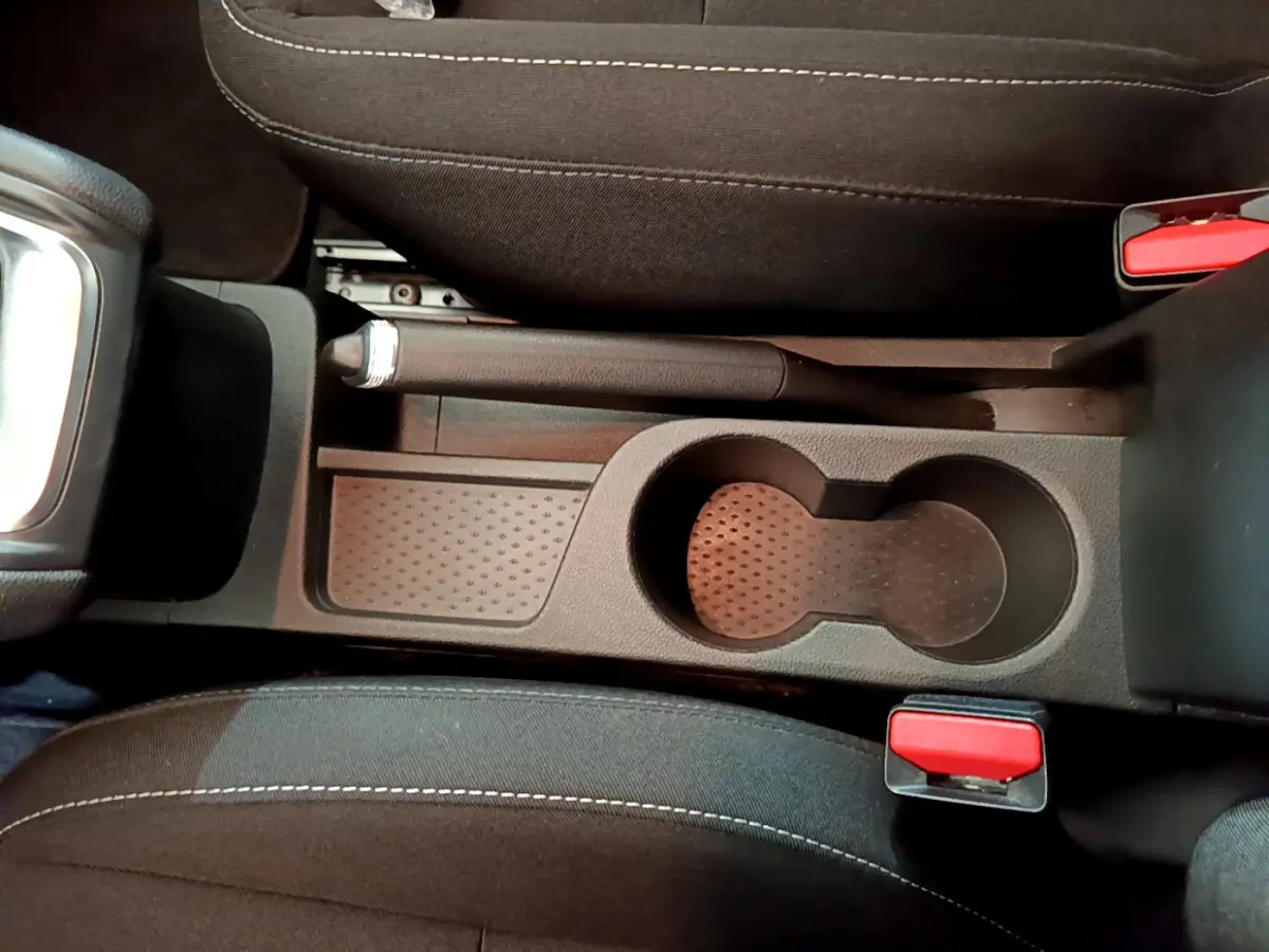 Vue plongeante sur la console centrale noire du Renault Captur 2020, avec frein à main manuel et porte-gobelets.