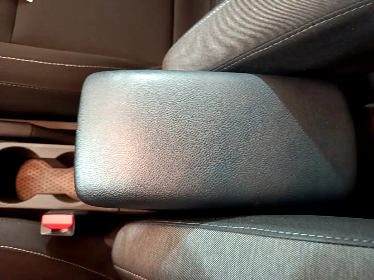 Vue rapprochée de l'accoudoir central noir et des sièges tissu gris du Renault Captur Business 2020.