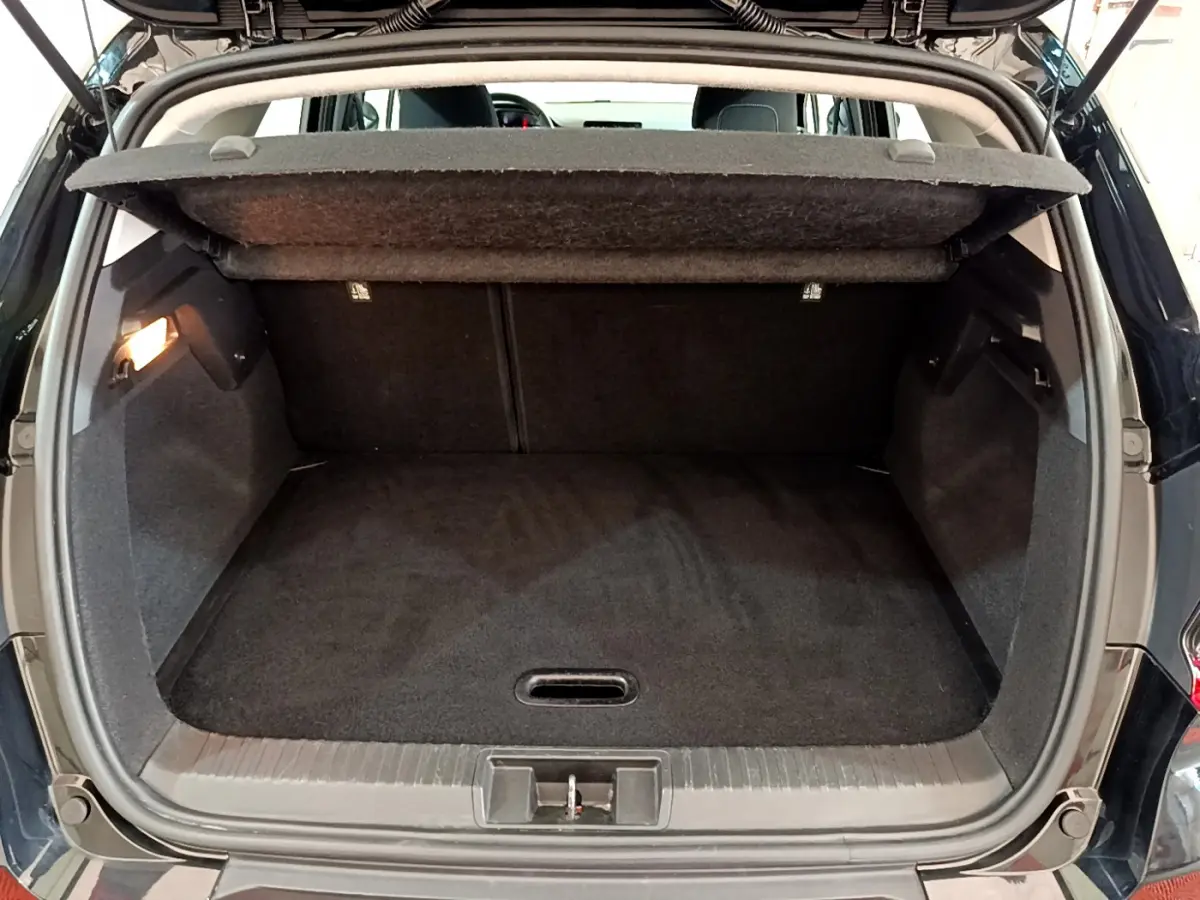 Vue arrière du coffre noir ouvert du Renault Captur Business Blue dCi 95 de 2020, montrant l'espace de chargement vide.