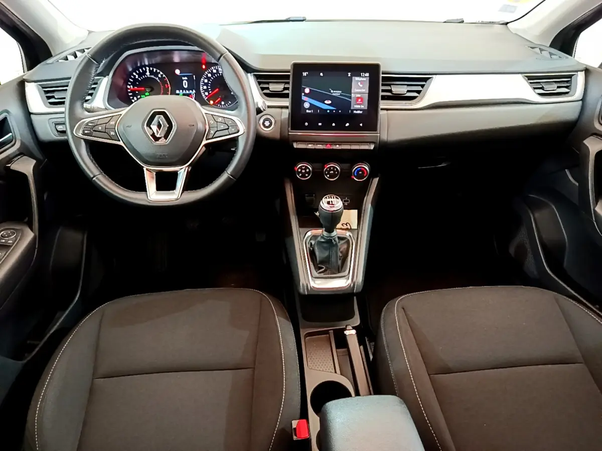Intérieur noir du Renault Captur 2020, vue avant centrée sur le volant multifonctions et l'écran tactile central.
