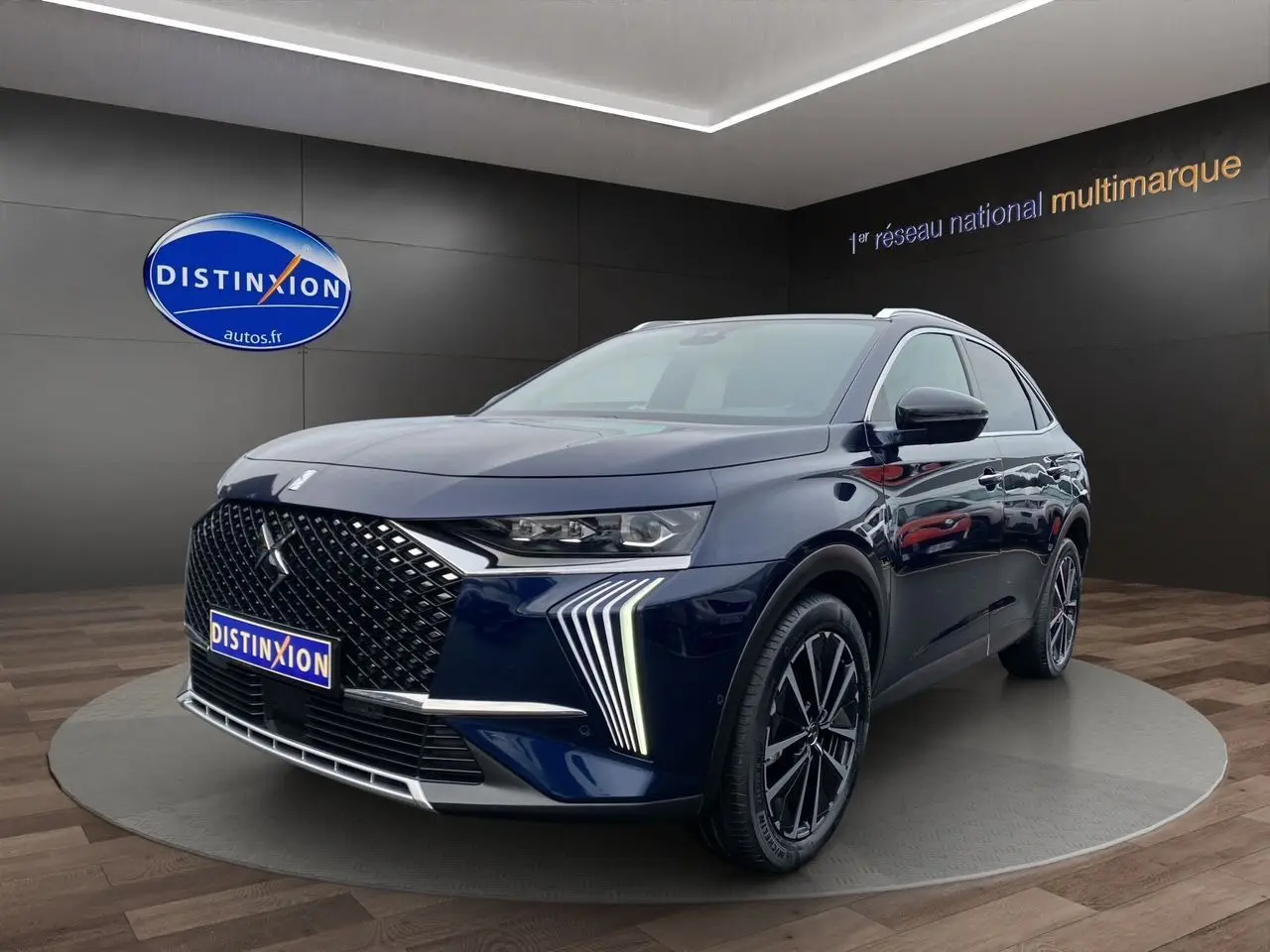 Vue 3/4 avant droit du DS7 2024 bleu éclipse avec calandre distinctive et feux LED en forme de griffes.