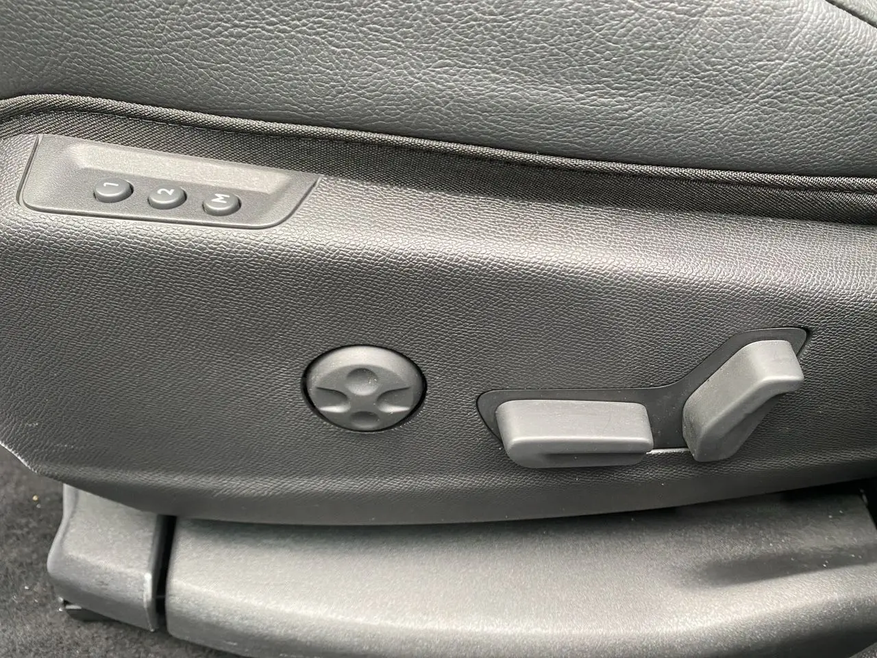 Détail des commandes de réglage électrique du siège en cuir noir du DS7 2024, côté gauche.