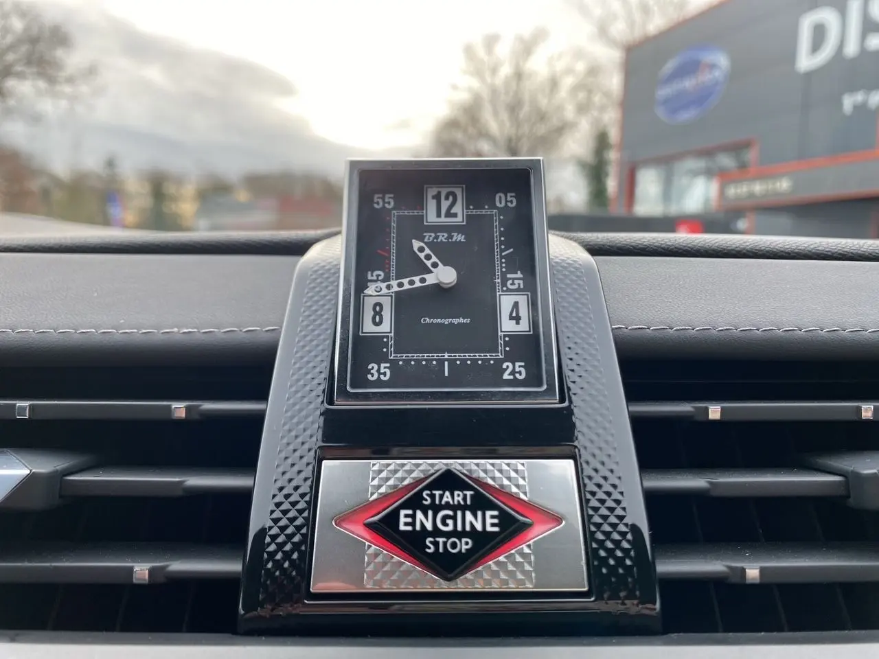 Gros plan sur la montre BRM et le bouton Start Engine Stop du tableau de bord du DS7 2024, sellerie cuir électrique.