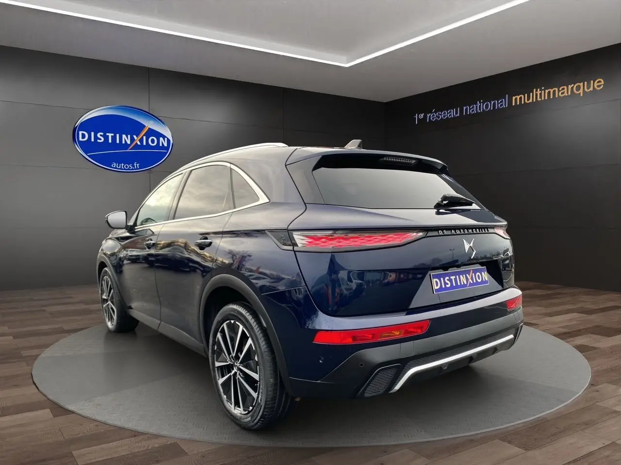 Vue 3/4 arrière du SUV DS7 Bleu Éclipse, avec feux arrière allongés et jantes alliage bicolores visibles.