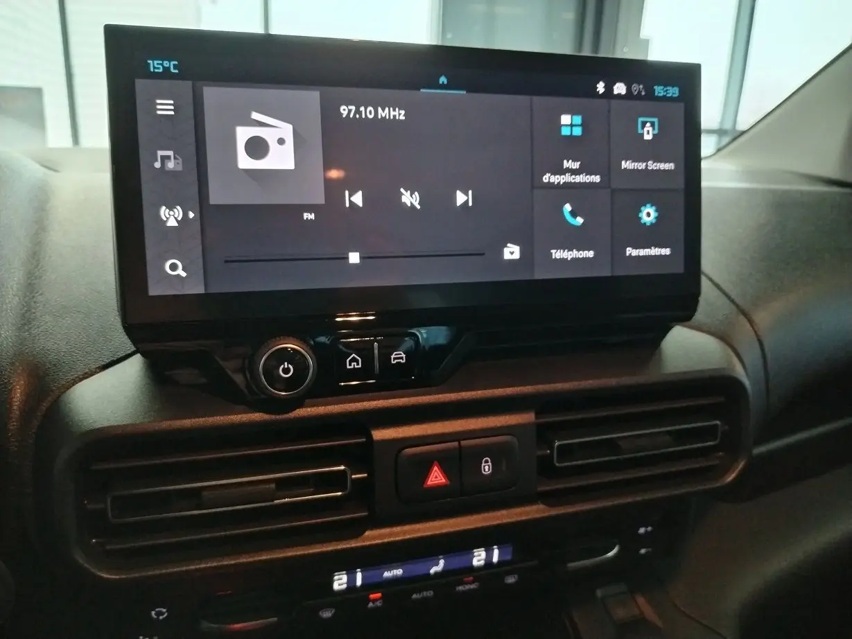 Vue rapprochée de l’écran tactile central du tableau de bord du Citroën Berlingo 2025 avec commandes numériques et climatisation.