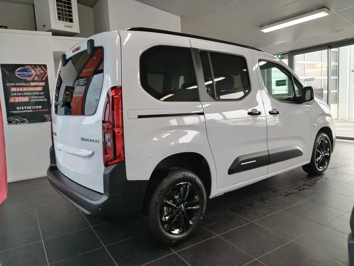 Vue 3/4 arrière droit du Citroën Berlingo blanc 2025 avec jantes alu noires Starlit et vitres teintées.