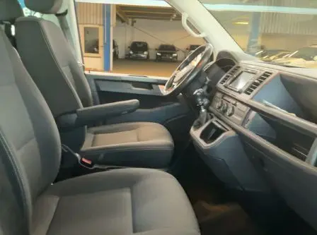 Intérieur côté conducteur du Volkswagen Multivan T6 2015 noir, montrant les sièges et le tableau de bord avec volant à gauche.