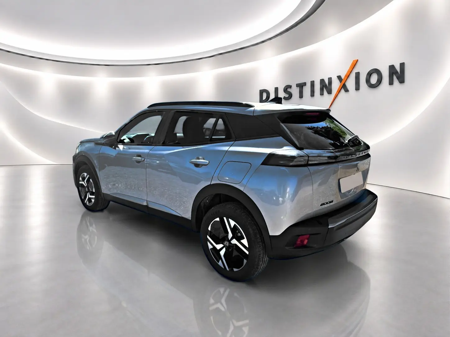 Peugeot 2008 gris Artense en vue 3/4 arrière droit, avec jantes alu et toit noir contrasté dans un showroom lumineux.