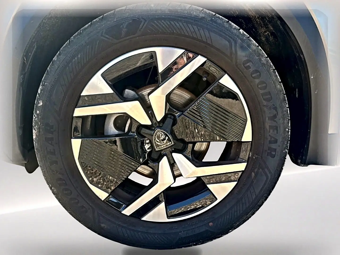 Gros plan sur la jante alu bicolore du Peugeot 2008 gris artense, mettant en valeur le design moderne et le pneu Goodyear.