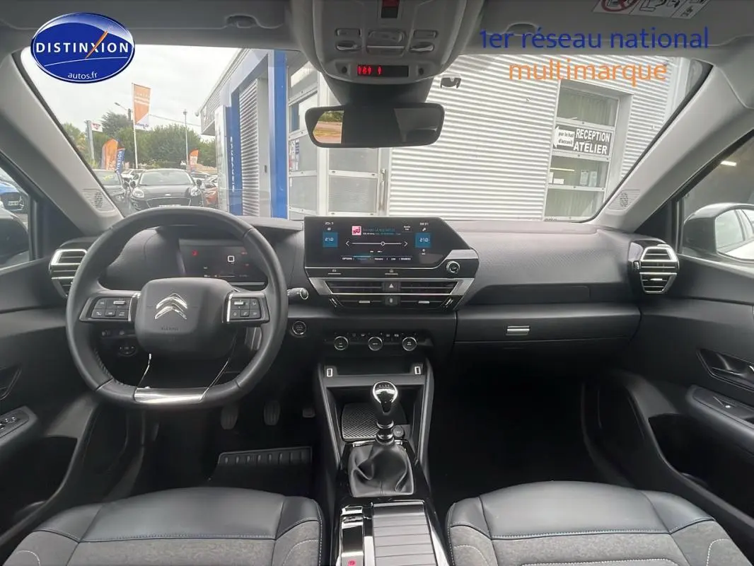 Intérieur du Citroën C4 blanc 2022, vue frontale du tableau de bord avec écran tactile et boîte manuelle.