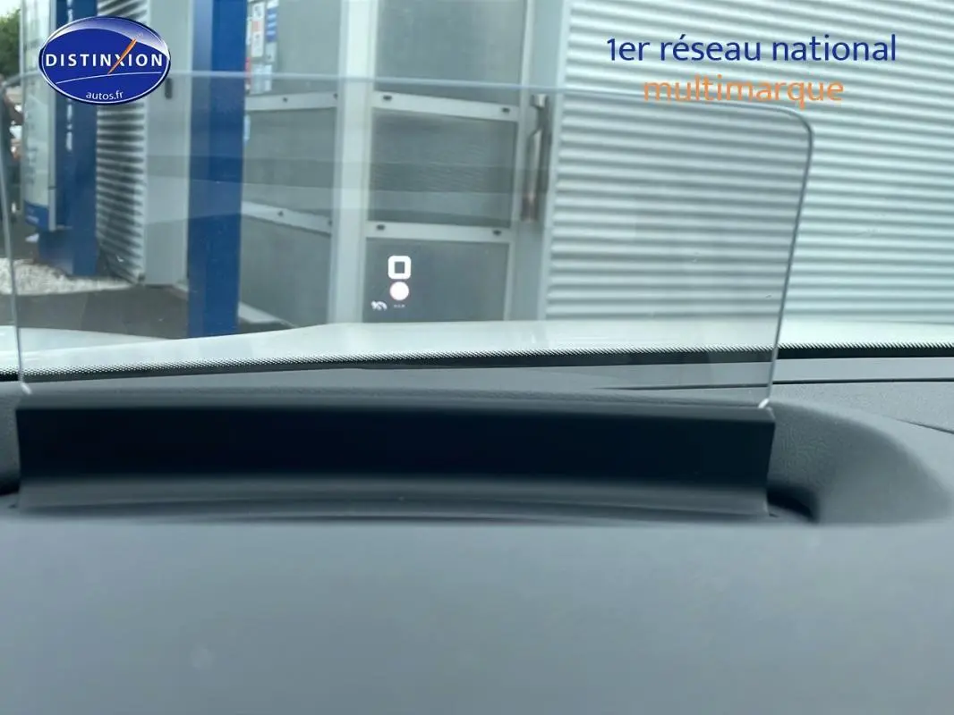 Affichage tête haute en fonctionnement sur le tableau de bord d'une Citroën C4 blanche, vue intérieure avant.