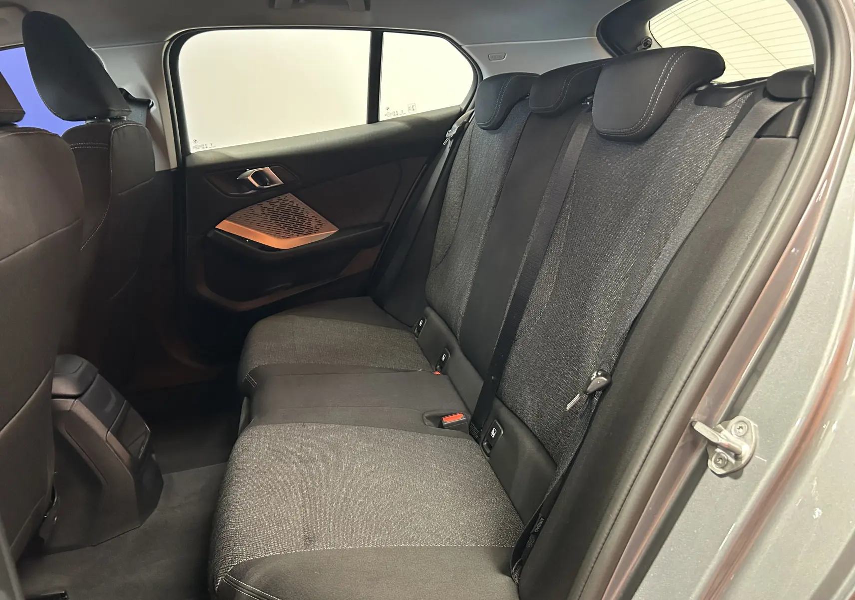Vue intérieure côté droit des sièges arrière en tissu gris de la BMW Série 1 120DA M Sport 2024 gris Skyscrap.