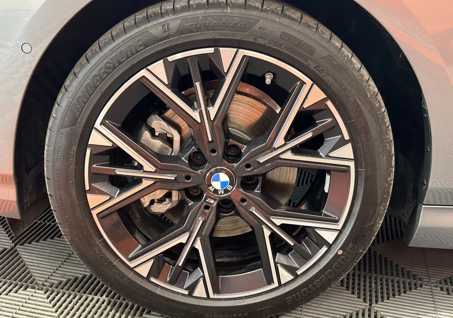 Gros plan sur la jante noire et argentée de la BMW Série 1 120DA gris Skyscrap avec logo BMW central visible.