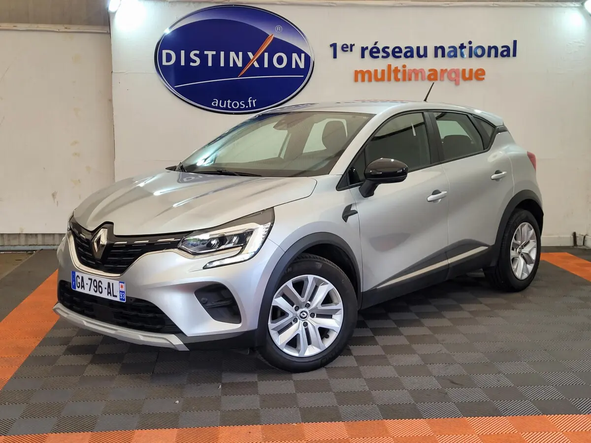 Renault Captur Business gris clair vu en 3/4 avant droit, avec jantes alliage et rétroviseurs noirs.
