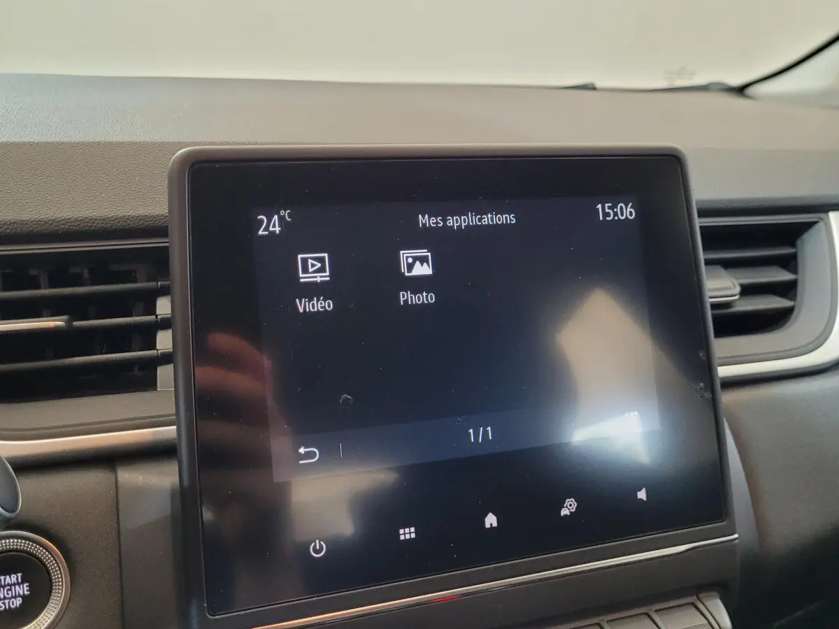 Écran tactile central affichant les applications vidéo et photo dans le tableau de bord du Renault Captur Business gris.