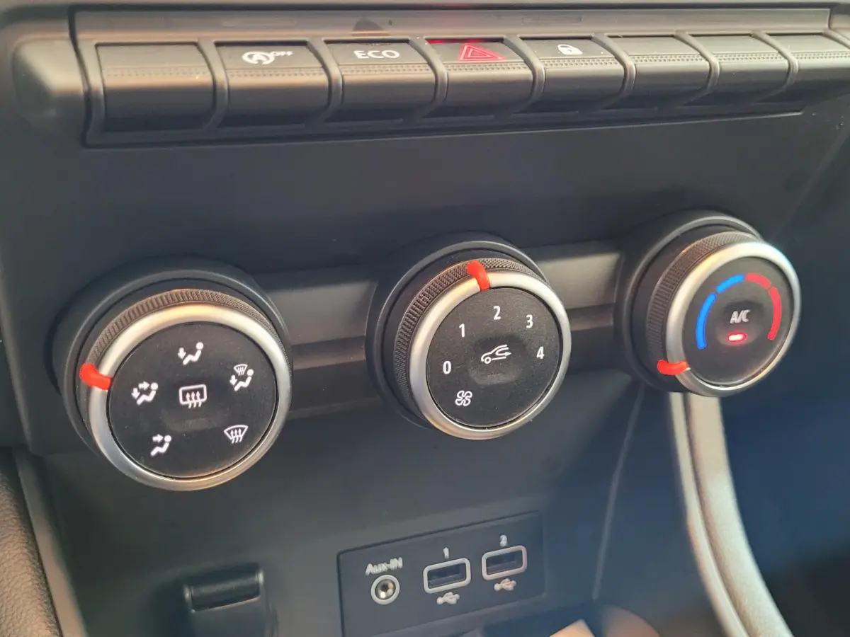 Gros plan sur les commandes de climatisation et ventilation du tableau de bord du Renault Captur gris clair 2021.