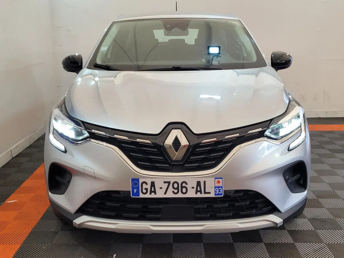 Vue frontale d'un Renault Captur Business Blue dCi 95 gris clair avec phares LED allumés et calandre noire.