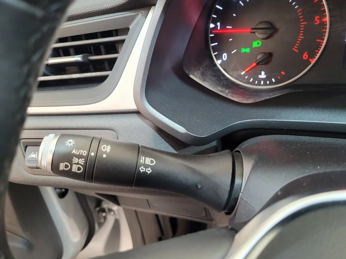 Gros plan sur la commande des phares et clignotants du tableau de bord gris du Renault Captur Business Blue dCi 95 2021.