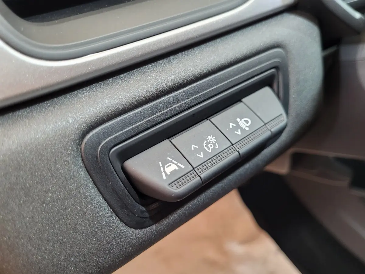 Gros plan sur les boutons de réglage d'assistance et éclairage du tableau de bord du Renault Captur Business gris clair 2021.