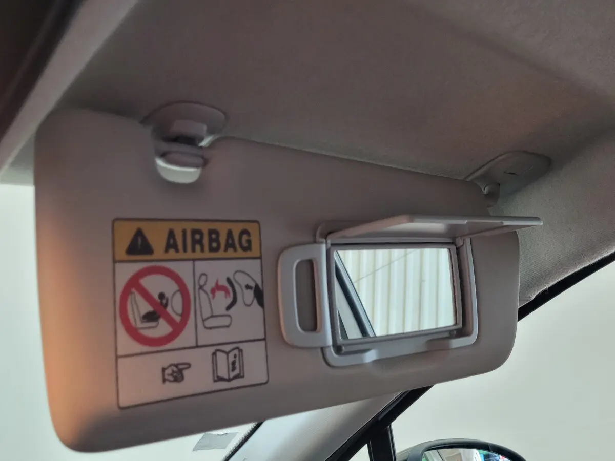 Miroir de courtoisie ouvert sur pare-soleil côté conducteur d'un Renault Captur gris clair 2021, intérieur lumineux.