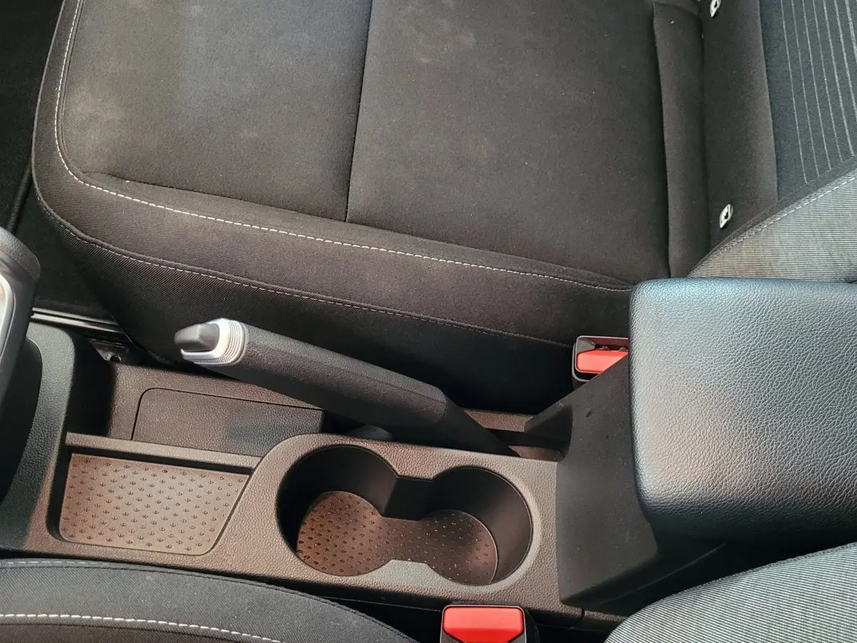 Vue plongeante sur la console centrale noire du Renault Captur 2021 avec frein à main manuel et porte-gobelets.