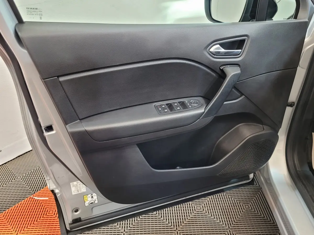Vue rapprochée de la porte avant gauche grise du Renault Captur Business Blue dCi 95 avec commandes de vitres et haut-parleur intégré.