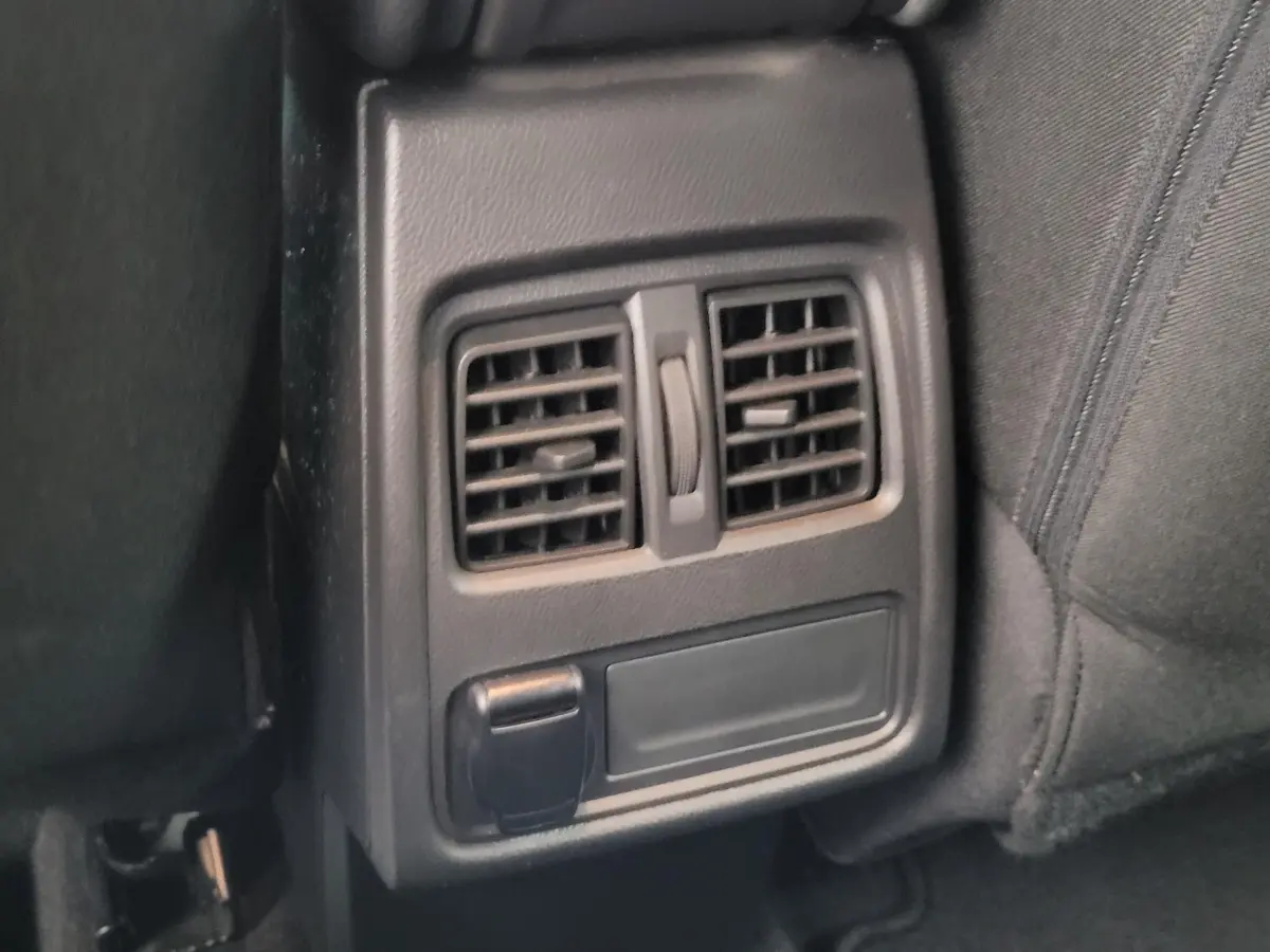 Détail des bouches d'aération arrière et prise 12V dans l'habitacle noir du Renault Captur Business 2021.