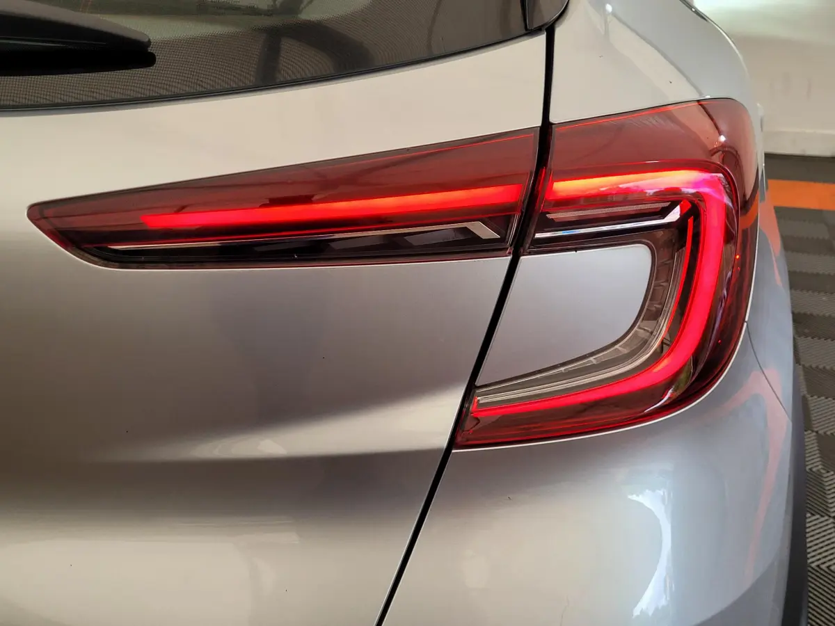 Gros plan sur le feu arrière droit rouge d'un Renault Captur Business gris clair 2021 dans un garage.
