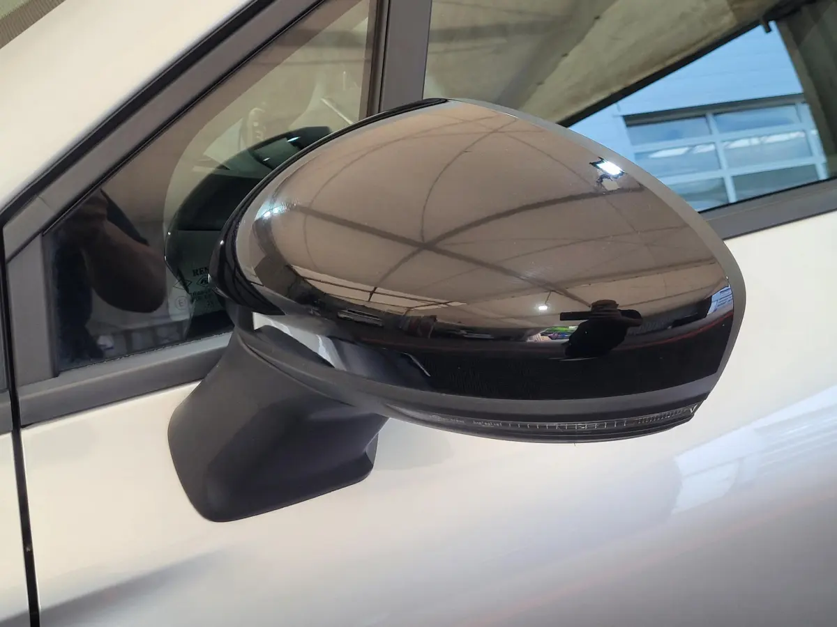 Rétroviseur extérieur droit noir brillant du Renault Captur gris clair, vue rapprochée sur porte côté conducteur.