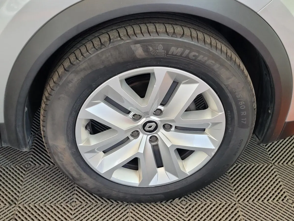 Gros plan sur la roue avant droite du Renault Captur gris clair, avec jante alliage et pneu Michelin visible.