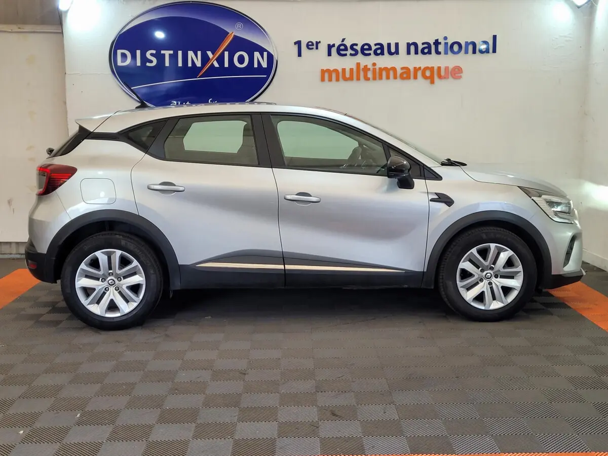 Profil côté droit d'un Renault Captur Business gris clair 2021, avec jantes alliage et protections noires sur les passages de roues.