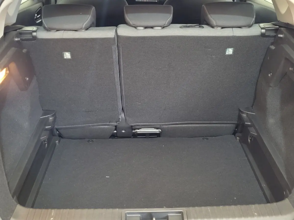 Vue intérieure du coffre noir du Renault Captur Business Blue dCi 95 gris clair, sièges arrière relevés.