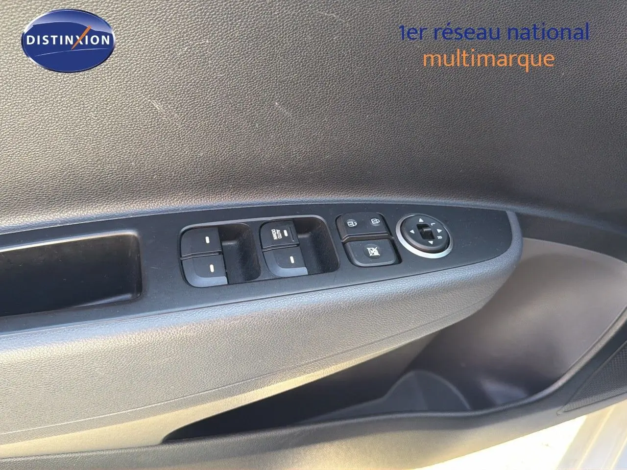 Gros plan sur la commande des vitres et rétroviseurs côté gauche d'une Hyundai i10 blanche 2018.