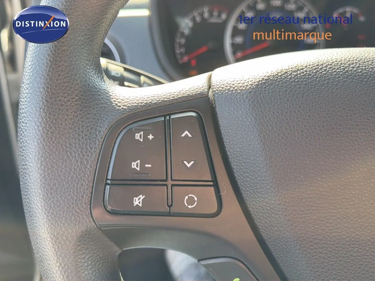 Gros plan sur les commandes audio au volant d'une Hyundai i10 blanche de 2018, version 1.0 66 Intuitive.